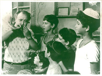 Meir Bar-Sheshet tests a shofar while neighbourhood children watch